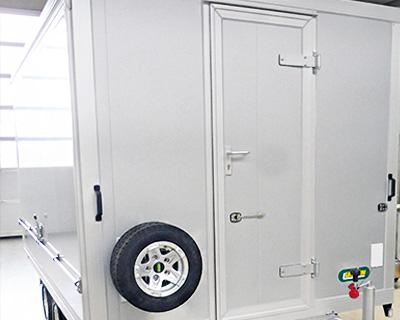 Tür mittig in der Stirnwand, mit Aluminium-Einfassung, Türdichtung, Türdrückergarnitur innen und außen mit Zylinderschloss, Durchgangsmaß H x B = 1800 x 650 mm, inkl. Auftritt auf die V-Deichsel